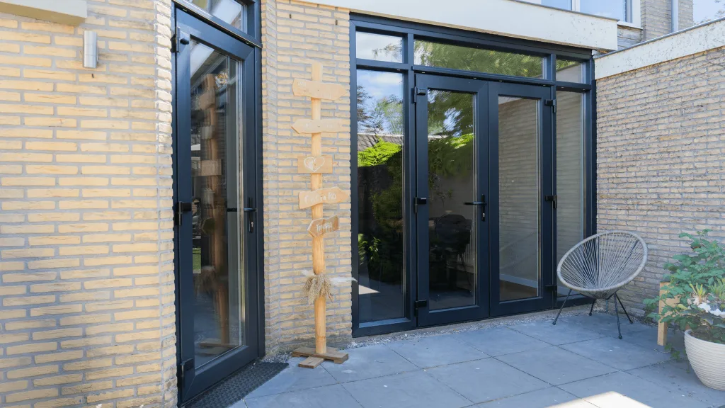 Antraciet tuindeuren met zijlichten naar een terras