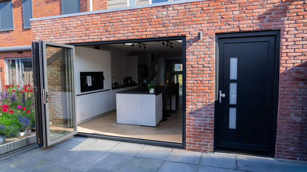 Antraciet aluminium schuifpui in de achtergevel van een woning