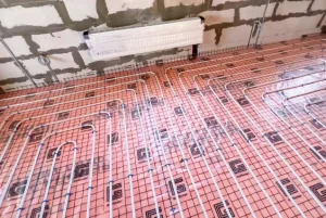 Vloerverwarming met leidingen op een isolatieplaat in een ruwbouw