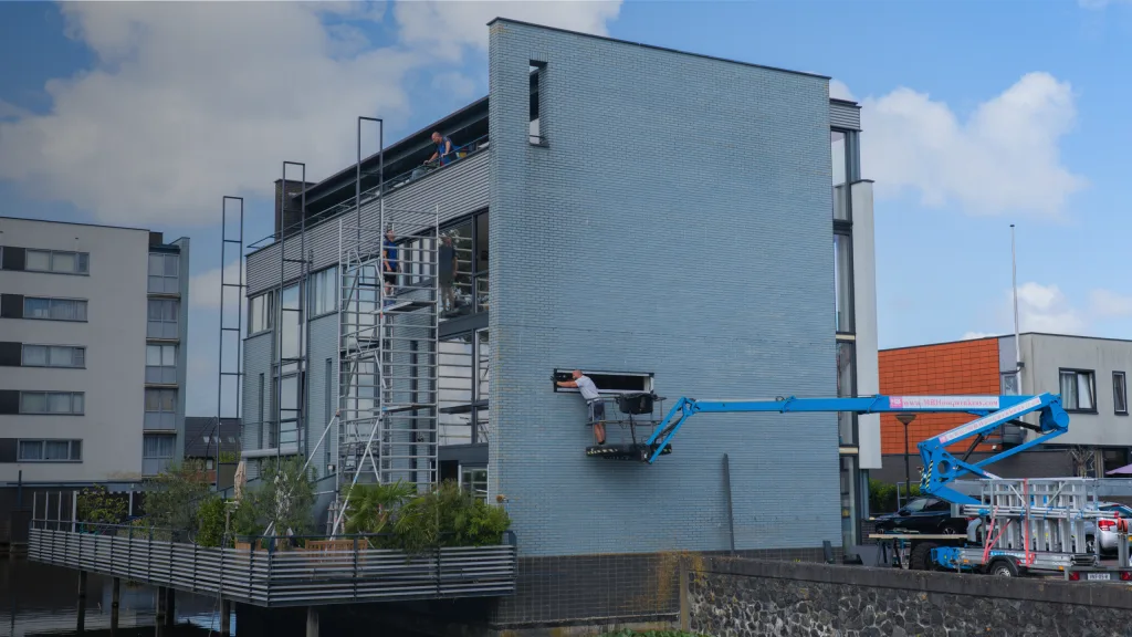 Hoogwerker bij een gevel tijdens het plaatsen van nieuwe kozijnen