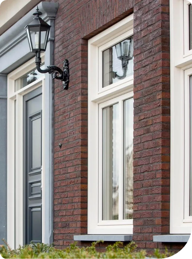 Witte kunststof kozijnen in een bakstenen gevel