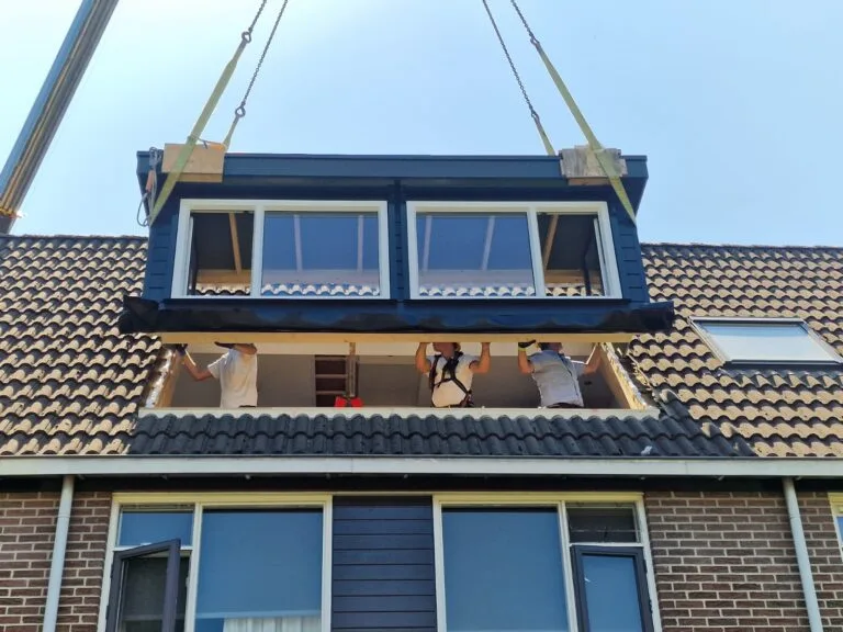 Kraan hijst een prefab dakkapel op het dak