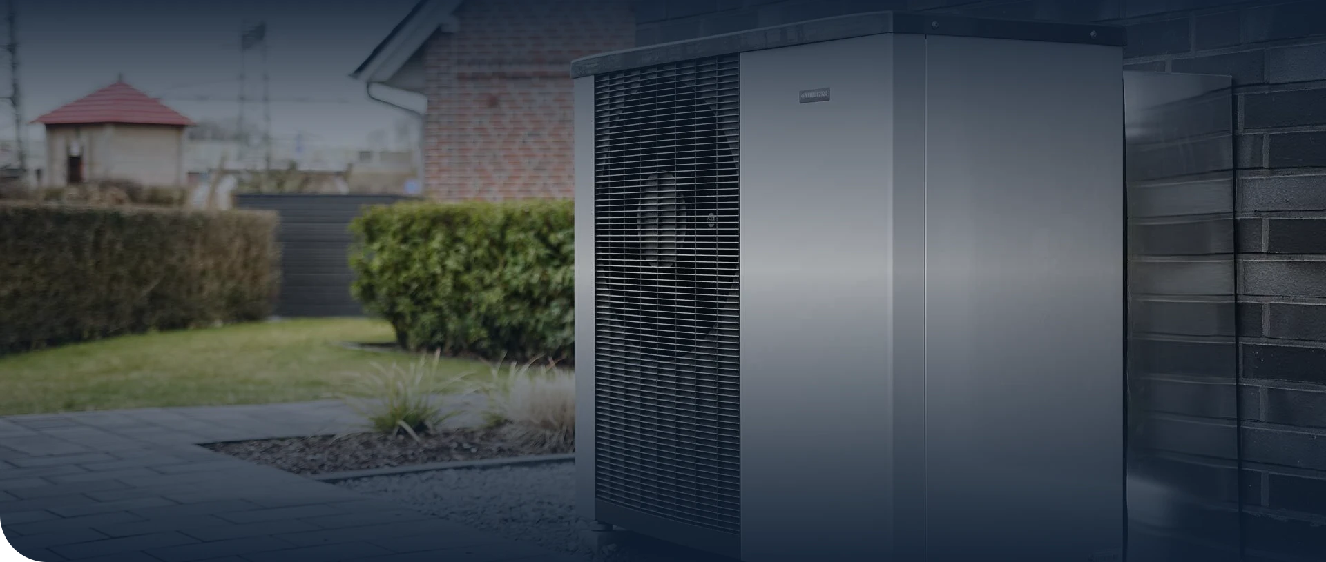 Buitenunit van een warmtepomp in de tuin