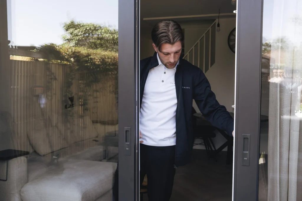 Adviseur van Ventasol loopt door een geopende schuifpui