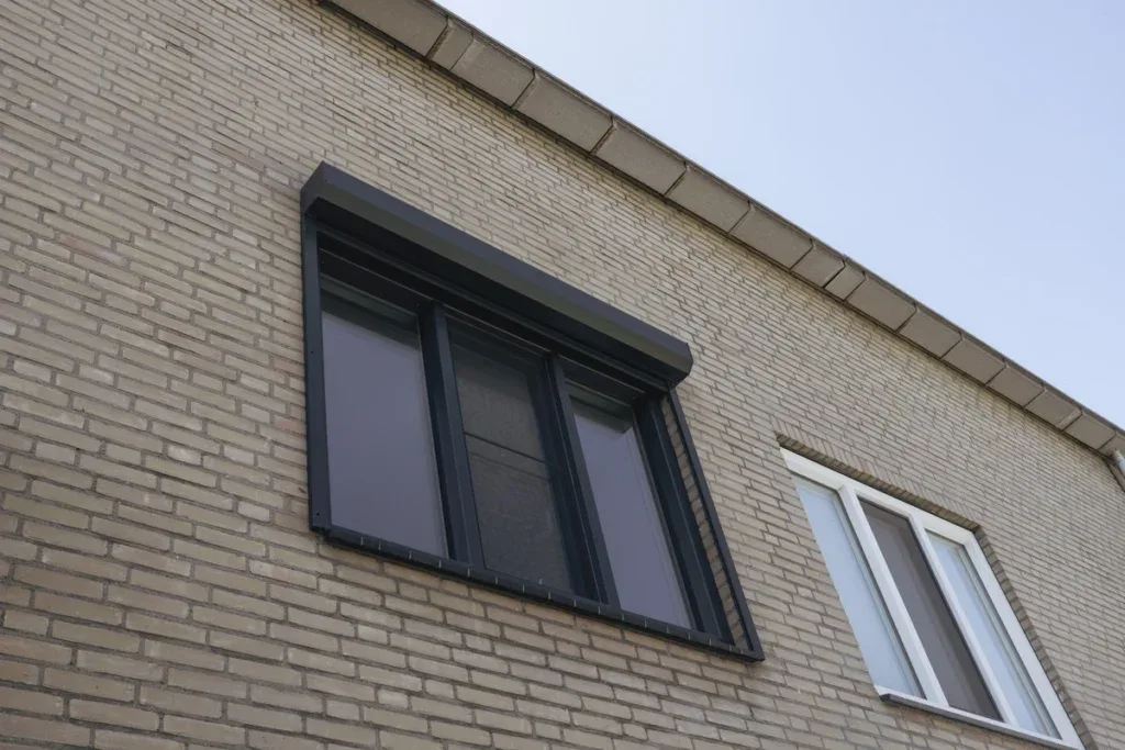 Antraciet kozijnen in een lichte bakstenen gevel