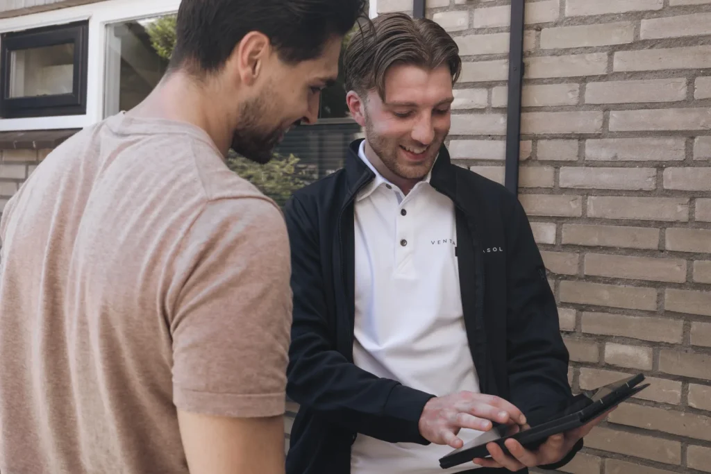 Adviseur bekijkt samen met de bewoner de gevel
