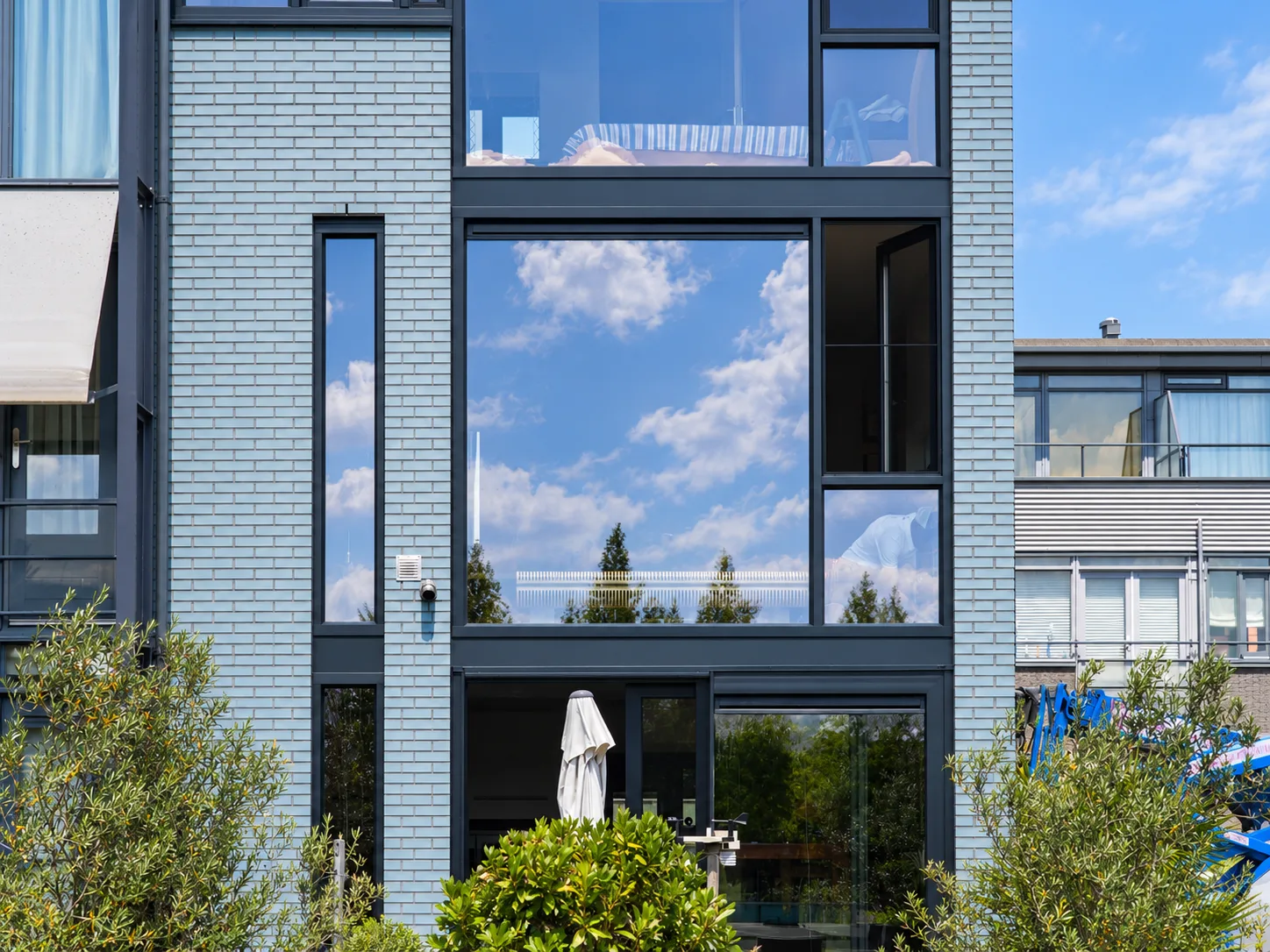 Moderne gevel met hoge antraciet kozijnen en glazen puien in Den Haag