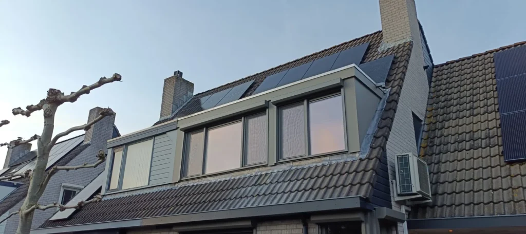 Twee grijze dakkapellen naast elkaar met zonnepanelen op het dak