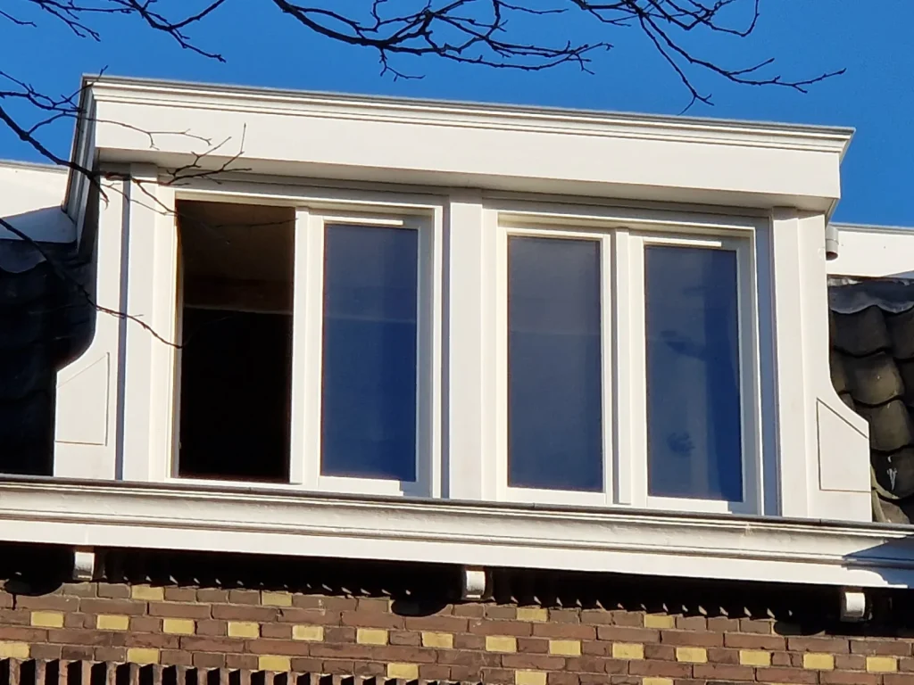 Klassieke witte dakkapel met kroonlijst en zijwangen van dichtbij