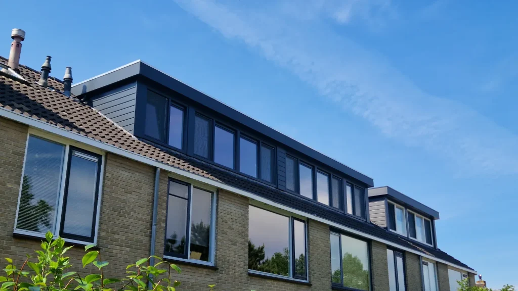 Lange antraciet dakkapel die over meerdere rijtjeswoningen doorloopt