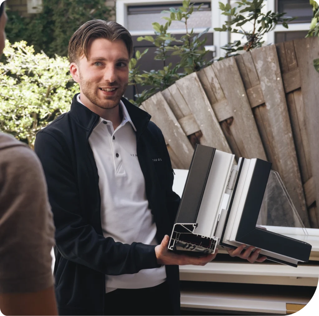 Adviseur van Ventasol toont kozijnprofielen in de tuin