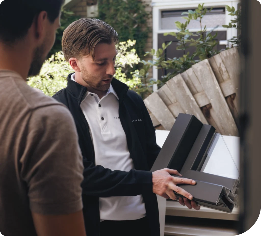 Adviseur toont kozijnprofielen aan een klant in de tuin