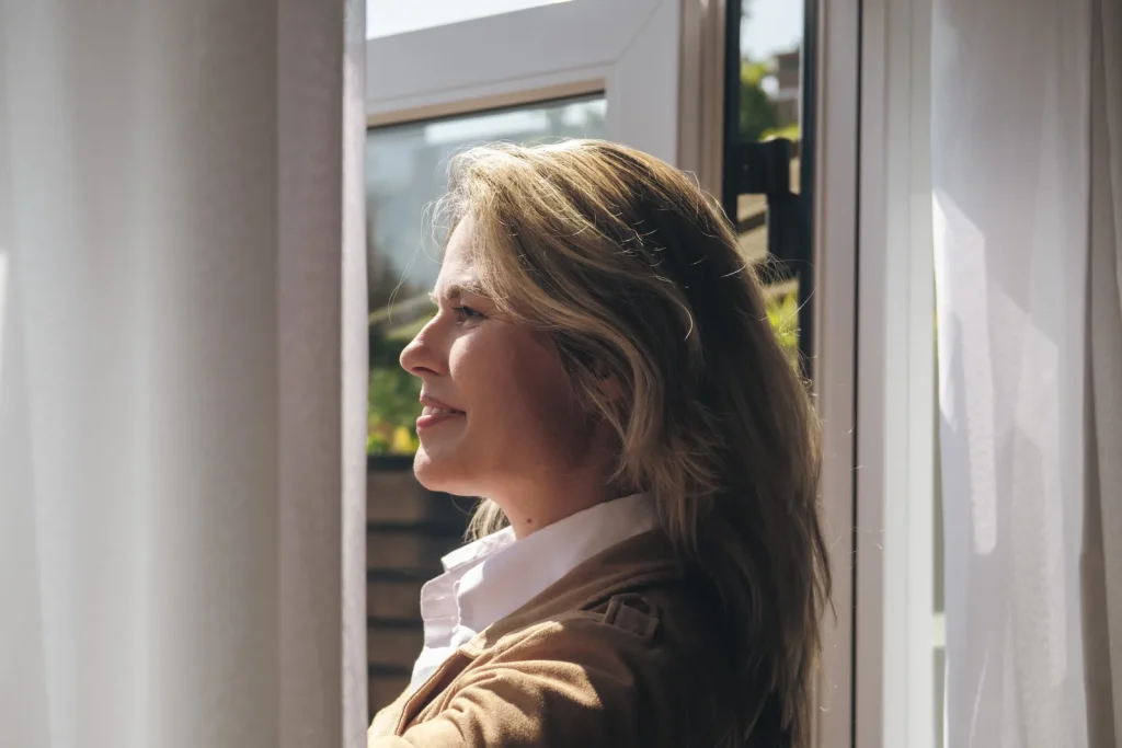 Bewoonster kijkt door haar nieuwe raam naar buiten