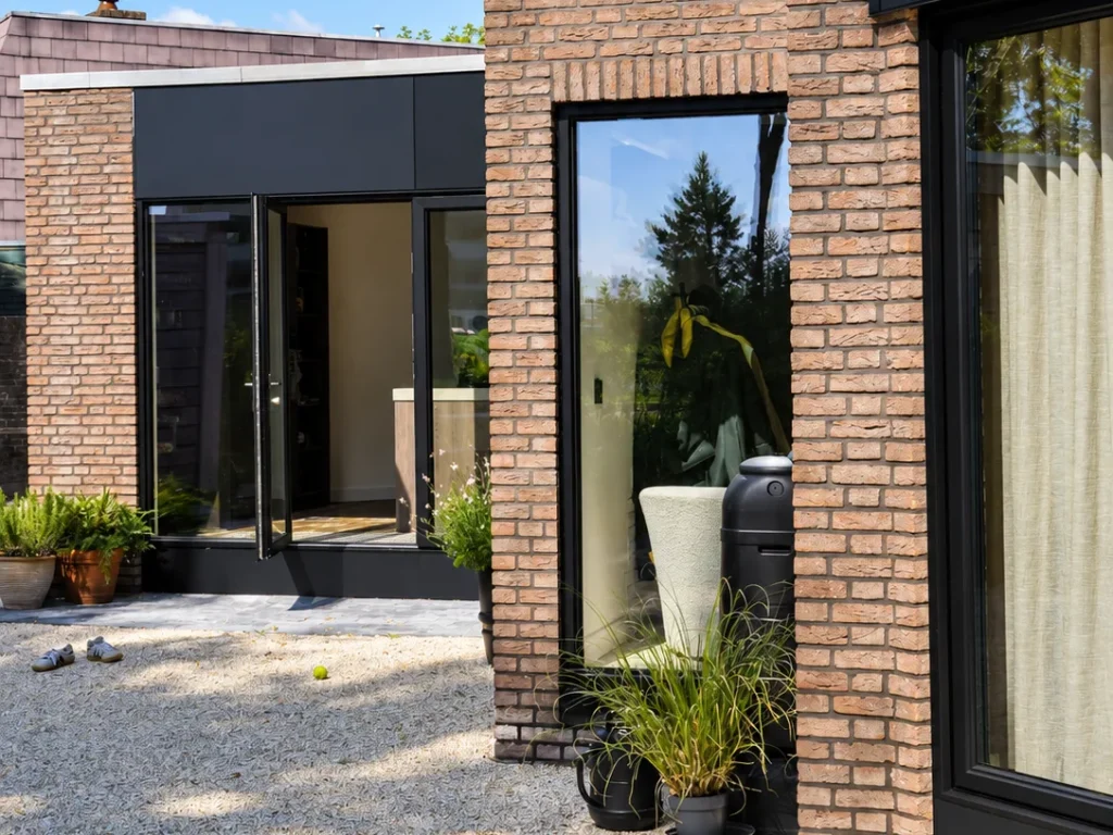 Moderne bakstenen woning met antraciet kozijnen en een grindtuin in Leiderdorp