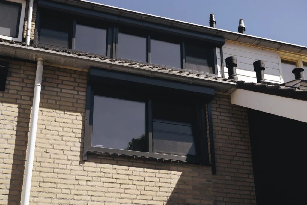 Woning met donkere kozijnen op de verdieping
