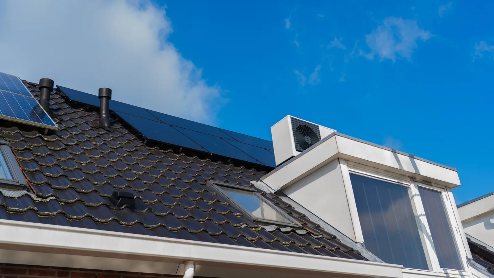 Zonnepanelen en een witte dakkapel op een pannendak in Bodegraven